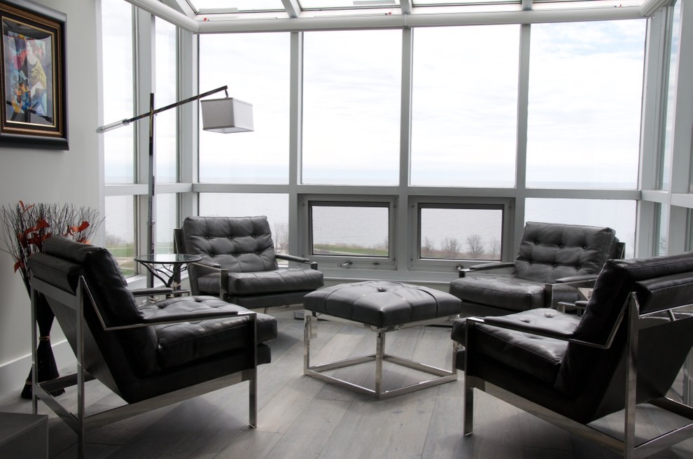 Foto de salón abierto moderno de tamaño medio con paredes grises, suelo de madera clara, chimenea lineal, marco de chimenea de yeso y televisor colgado en la pared
