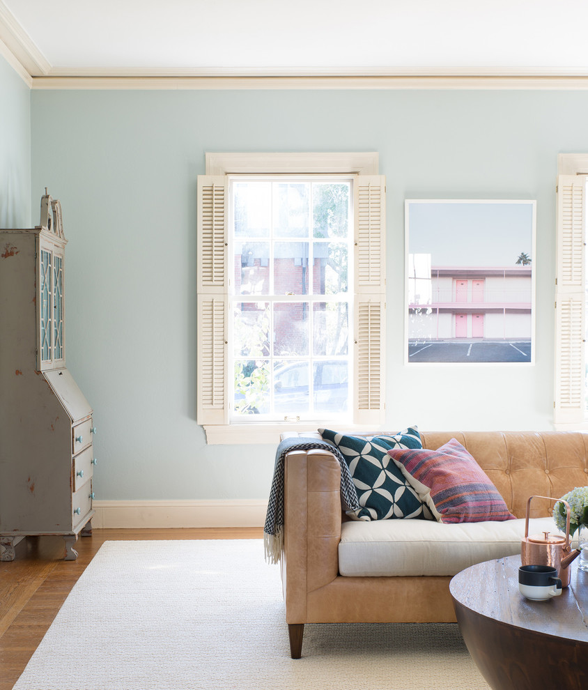 Cette photo montre un salon éclectique avec un mur bleu, un sol en bois brun, une cheminée standard et un manteau de cheminée en bois.