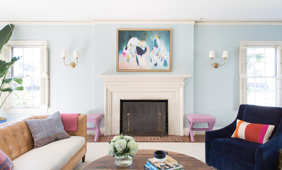 Exemple d'un salon éclectique avec un mur bleu, un sol en bois brun, une cheminée standard et un manteau de cheminée en bois.