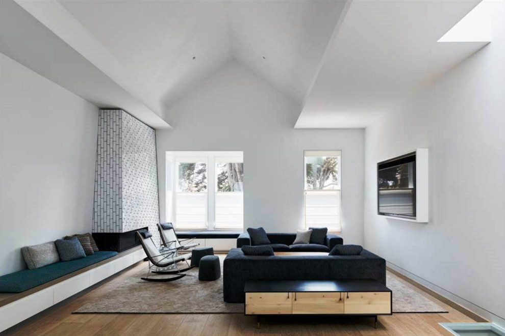 Esempio di un grande soggiorno minimalista stile loft con sala formale, pareti bianche, parquet chiaro, camino lineare Ribbon e cornice del camino piastrellata
