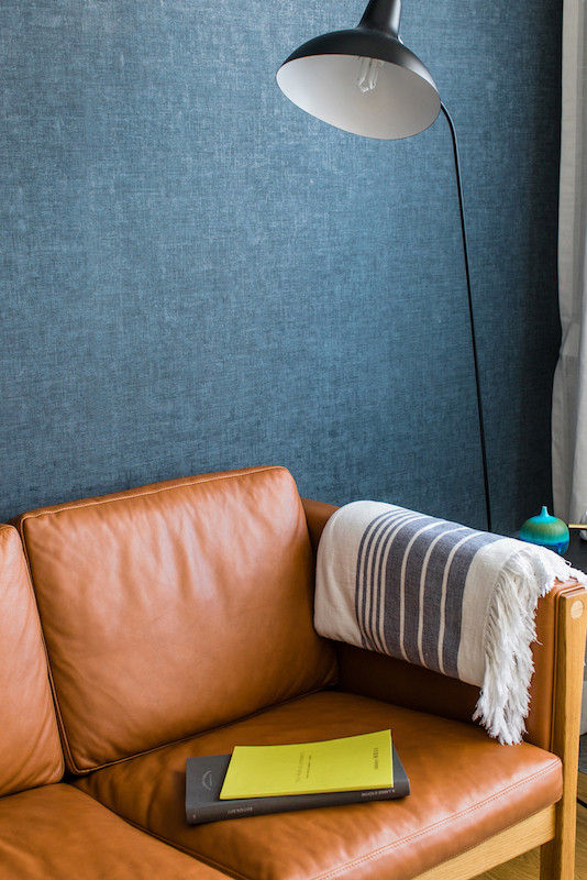 Immagine di un piccolo soggiorno minimalista aperto con sala formale, pareti multicolore, pavimento in legno massello medio, nessun camino, nessuna TV e pavimento marrone