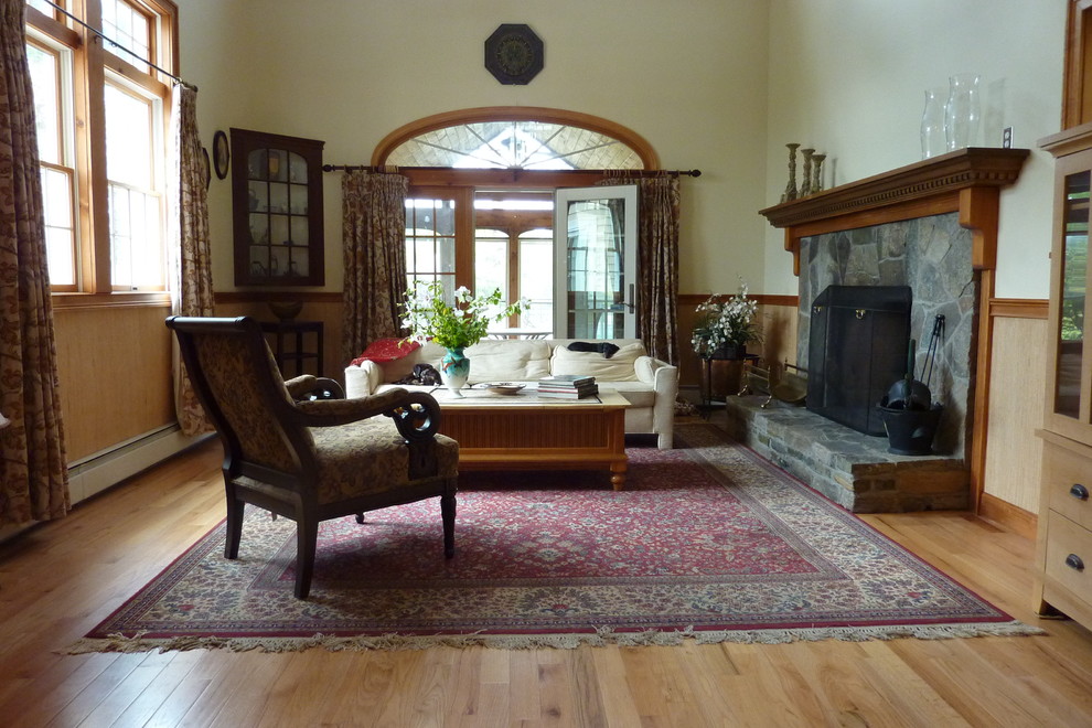 Aménagement d'un grand salon classique ouvert avec un mur beige, un sol en bois brun, une cheminée standard, un manteau de cheminée en pierre, aucun téléviseur et un sol marron.