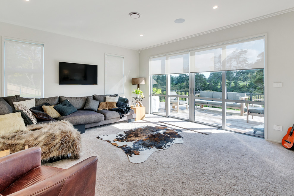 Mittelgroßes, Offenes Modernes Wohnzimmer mit Teppichboden, TV-Wand und beigem Boden in Auckland