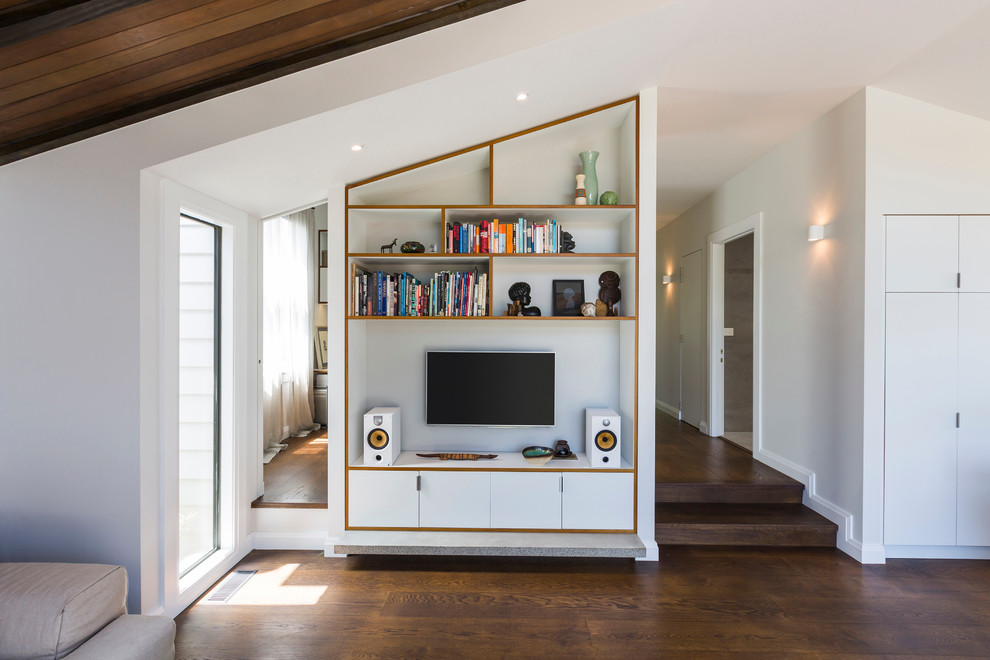 На фото: маленькая открытая гостиная комната в современном стиле с телевизором на стене и белыми стенами для на участке и в саду