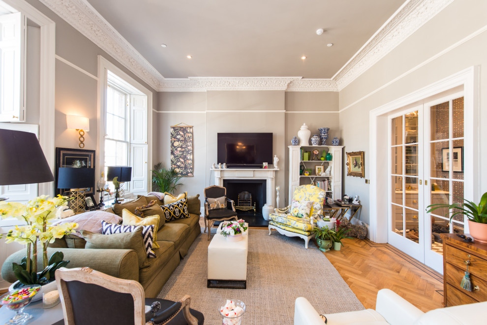 Inspiration for a traditional enclosed living room in Other with grey walls, medium hardwood flooring, a standard fireplace, a wall mounted tv and brown floors.