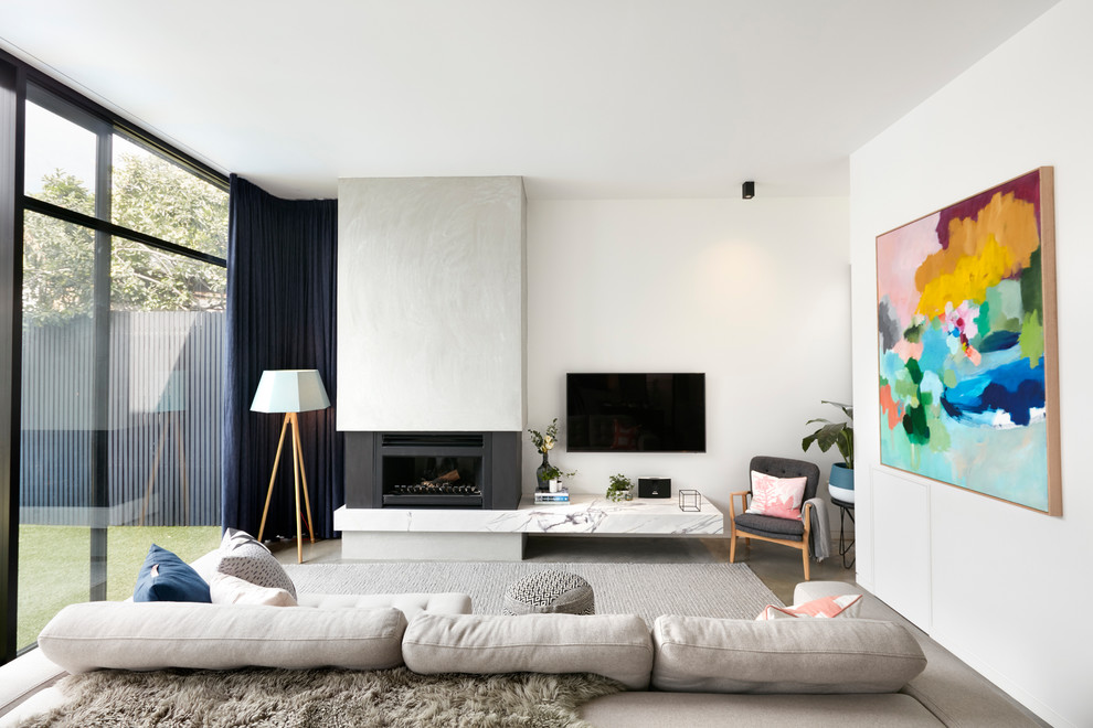 メルボルンにある高級な中くらいなトラディショナルスタイルのおしゃれなLDK (白い壁、コンクリートの床、石材の暖炉まわり、壁掛け型テレビ、グレーの床) の写真