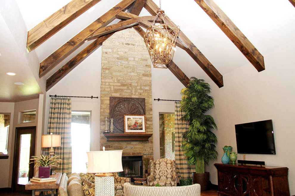 Пример оригинального дизайна: открытая гостиная комната среднего размера в стиле неоклассика (современная классика) с стандартным камином, бежевыми стенами, паркетным полом среднего тона, фасадом камина из камня, телевизором на стене и коричневым полом
