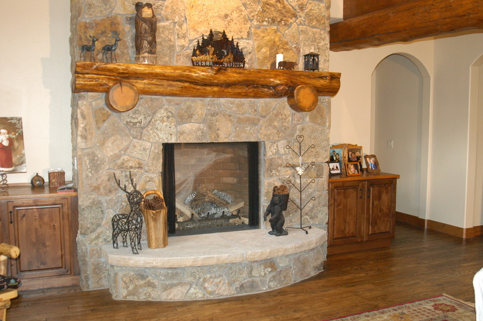 Bild på ett mellanstort rustikt separat vardagsrum, med ett finrum, vita väggar, mellanmörkt trägolv, en standard öppen spis, en spiselkrans i sten och brunt golv