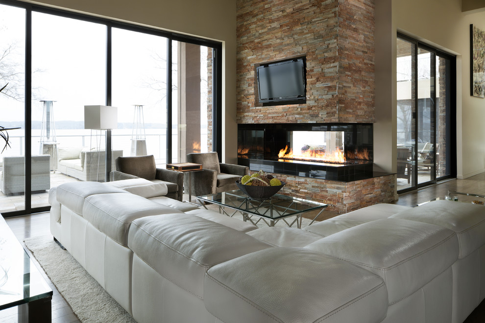 Trendy porcelain tile living room photo in Other with multicolored walls, a two-sided fireplace, a stone fireplace and a media wall