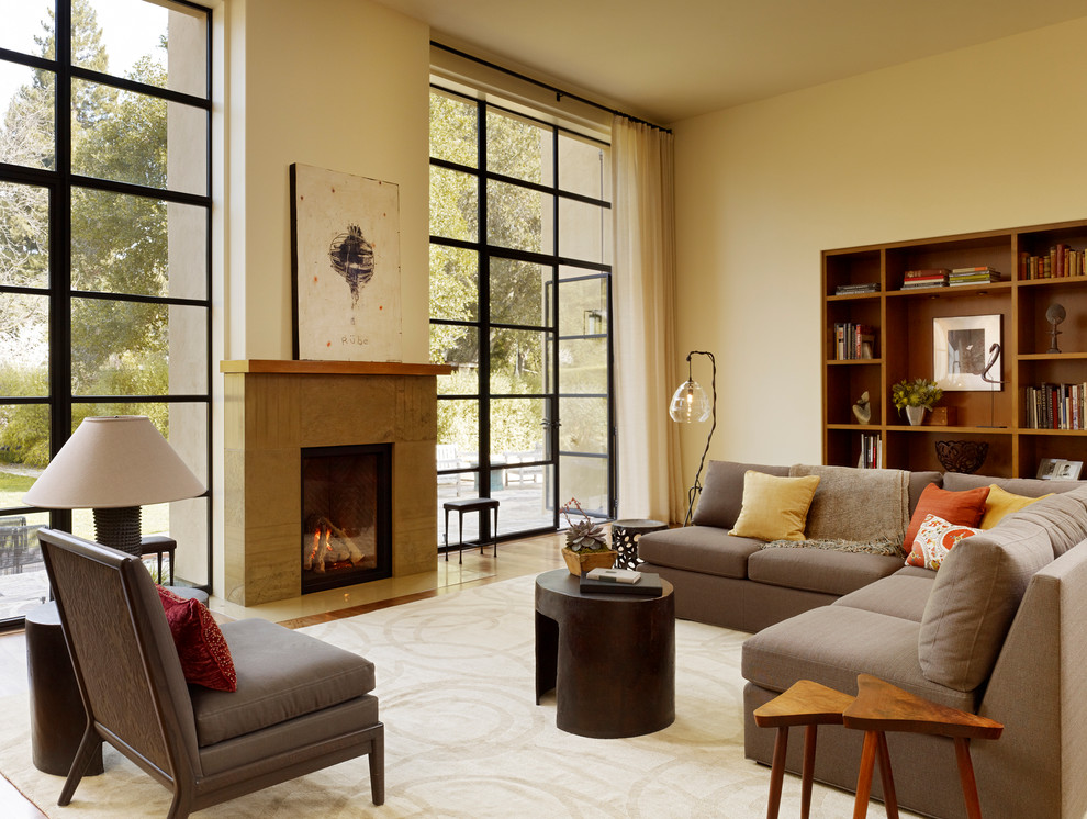 Ispirazione per un soggiorno moderno con pareti beige e camino classico