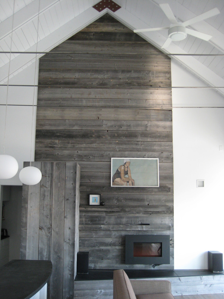 Inspiration för ett mellanstort funkis vardagsrum, med vita väggar, mellanmörkt trägolv, en hängande öppen spis, en spiselkrans i metall och grått golv