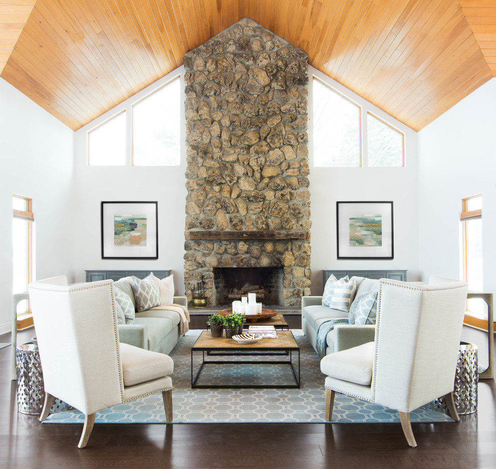 Rural living room in Toronto with white walls, dark hardwood flooring, a standard fireplace and a stone fireplace surround.
