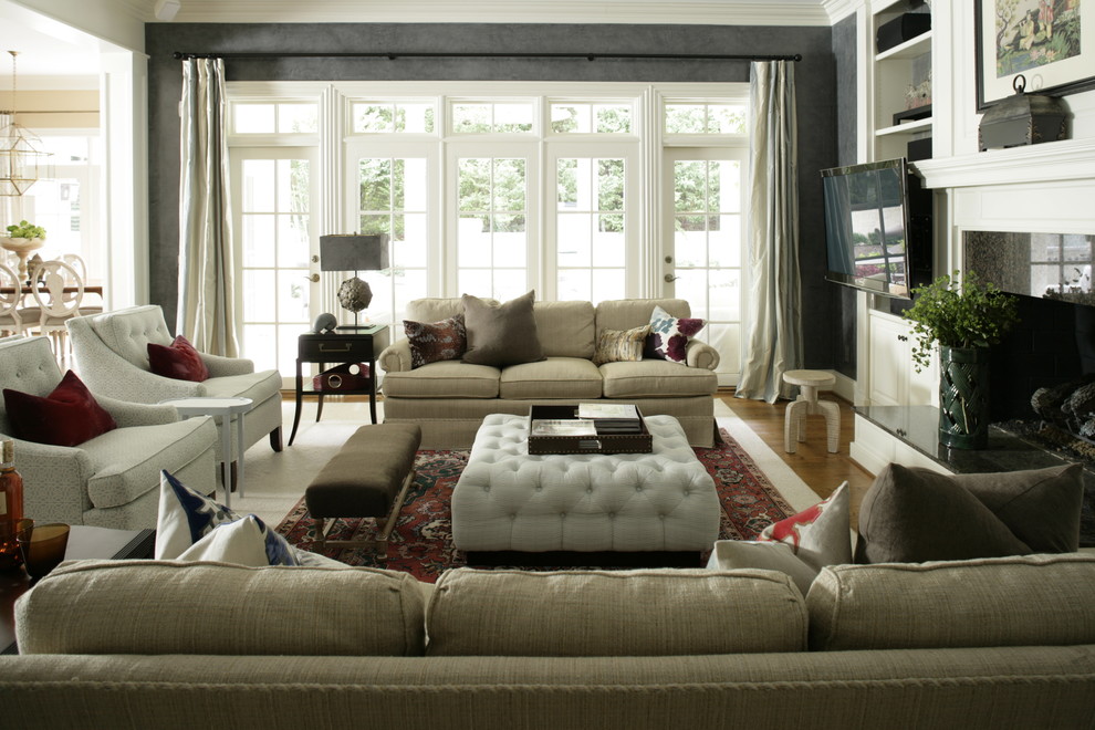 Diseño de salón abierto clásico con televisor colgado en la pared, paredes beige, suelo de madera en tonos medios y todas las chimeneas