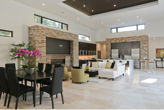 Example of a large minimalist open concept travertine floor living room design in Phoenix with white walls, a standard fireplace, a stone fireplace and a media wall
