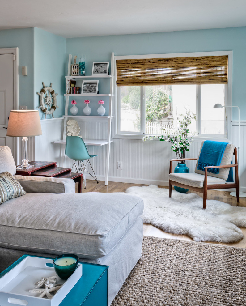 Idee per un soggiorno stile marinaro con pareti blu e pavimento in legno massello medio