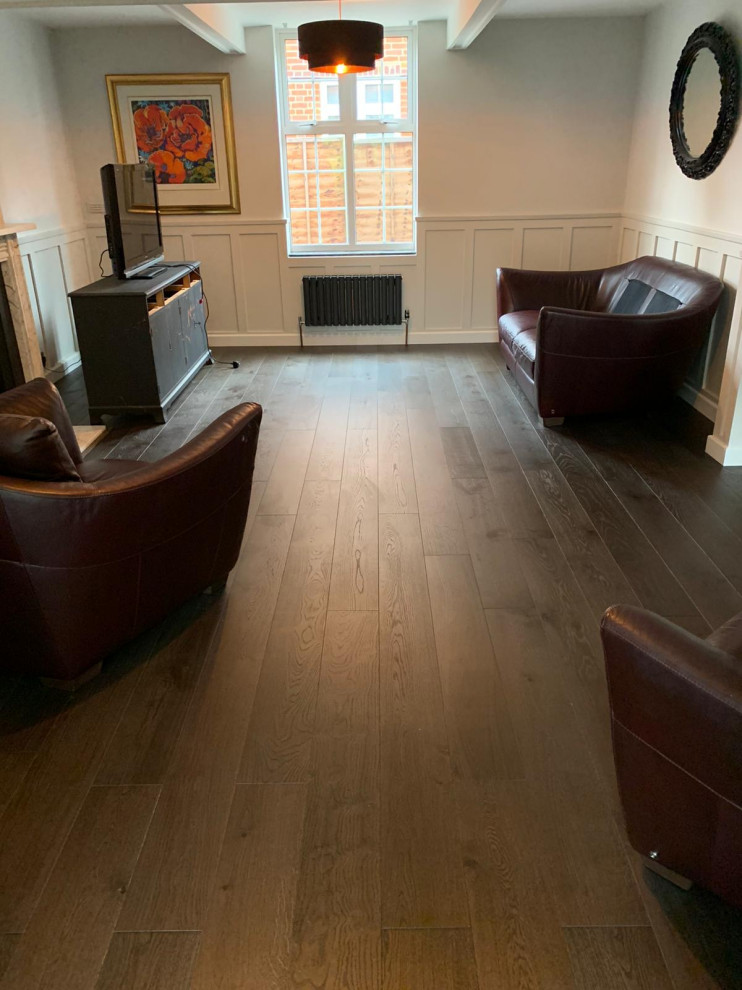 Imagen de salón cerrado clásico renovado de tamaño medio con paredes blancas, marco de chimenea de madera, televisor independiente y suelo marrón