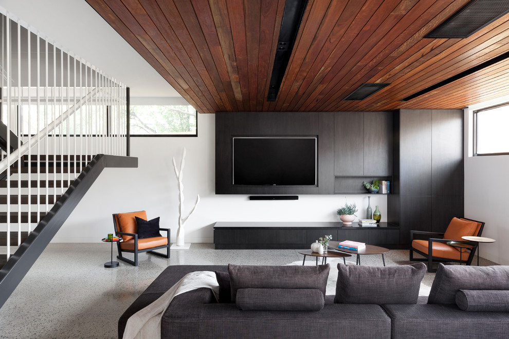 Aménagement d'un petit salon moderne ouvert avec un mur blanc, un téléviseur fixé au mur, un sol gris et sol en béton ciré.