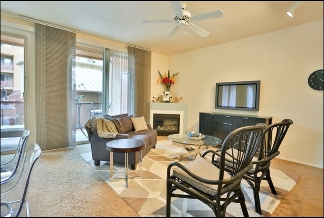 Small contemporary open plan living room in Phoenix with white walls, carpet, a corner fireplace and a wall mounted tv.