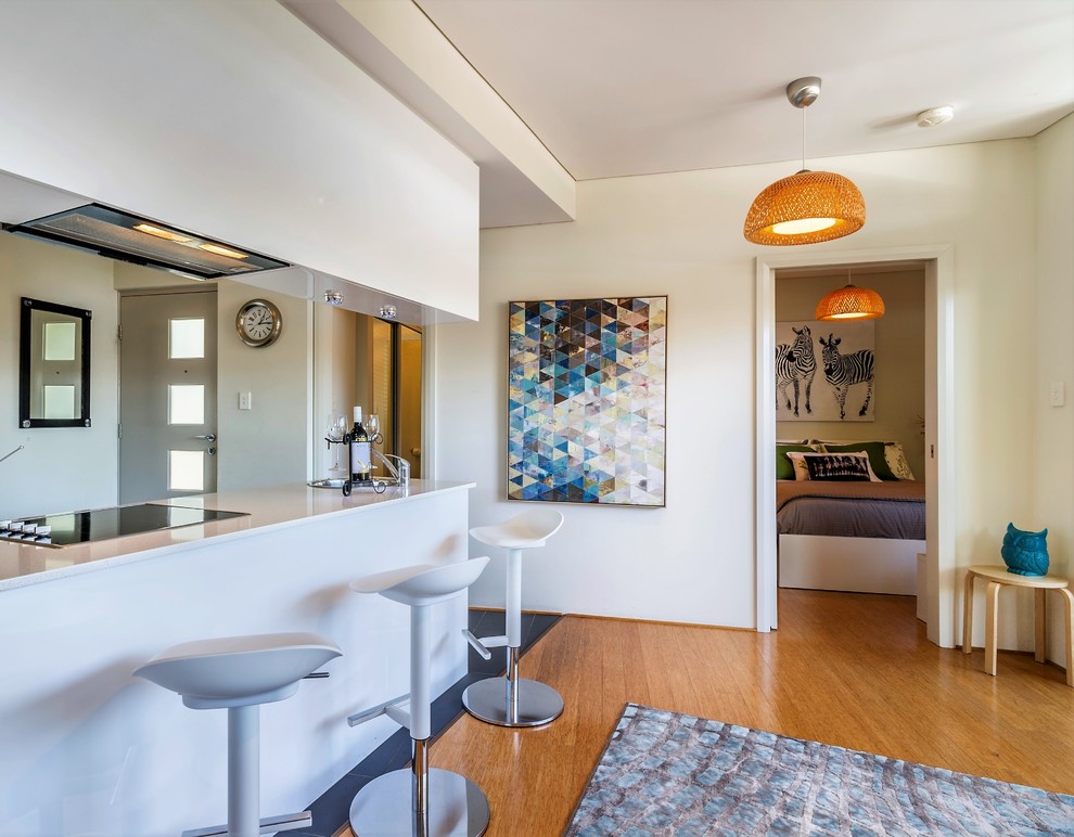 Пример оригинального дизайна: маленькая открытая гостиная комната в современном стиле с белыми стенами, полом из ламината и коричневым полом для на участке и в саду
