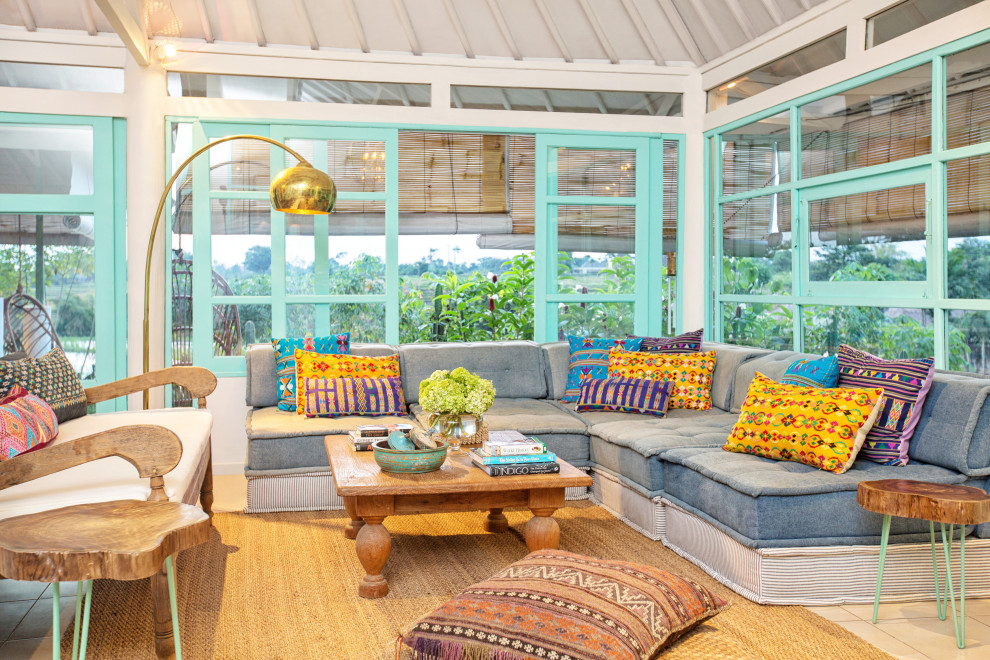Esempio di un grande soggiorno tropicale aperto con pareti bianche e pavimento beige