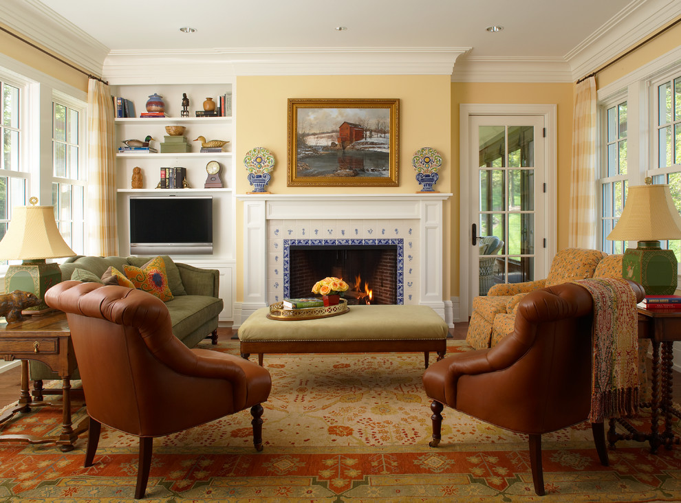 This is an example of a medium sized classic formal open plan living room in Detroit with yellow walls, medium hardwood flooring, a standard fireplace, a tiled fireplace surround and a freestanding tv.