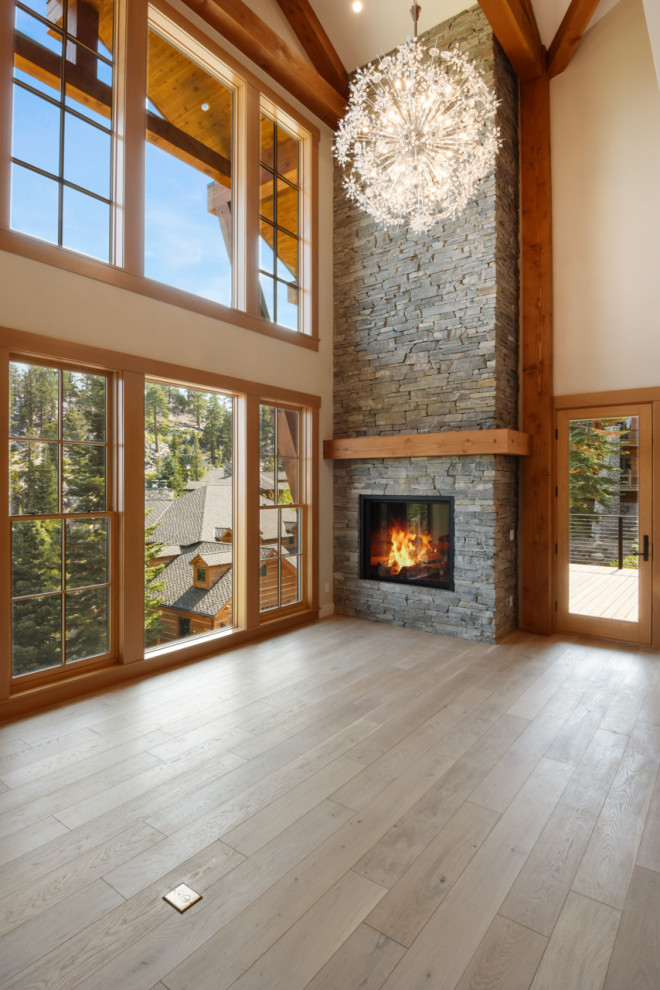 This is an example of a large classic formal open plan living room in Other with white walls, light hardwood flooring, a standard fireplace, a stone fireplace surround and beige floors.