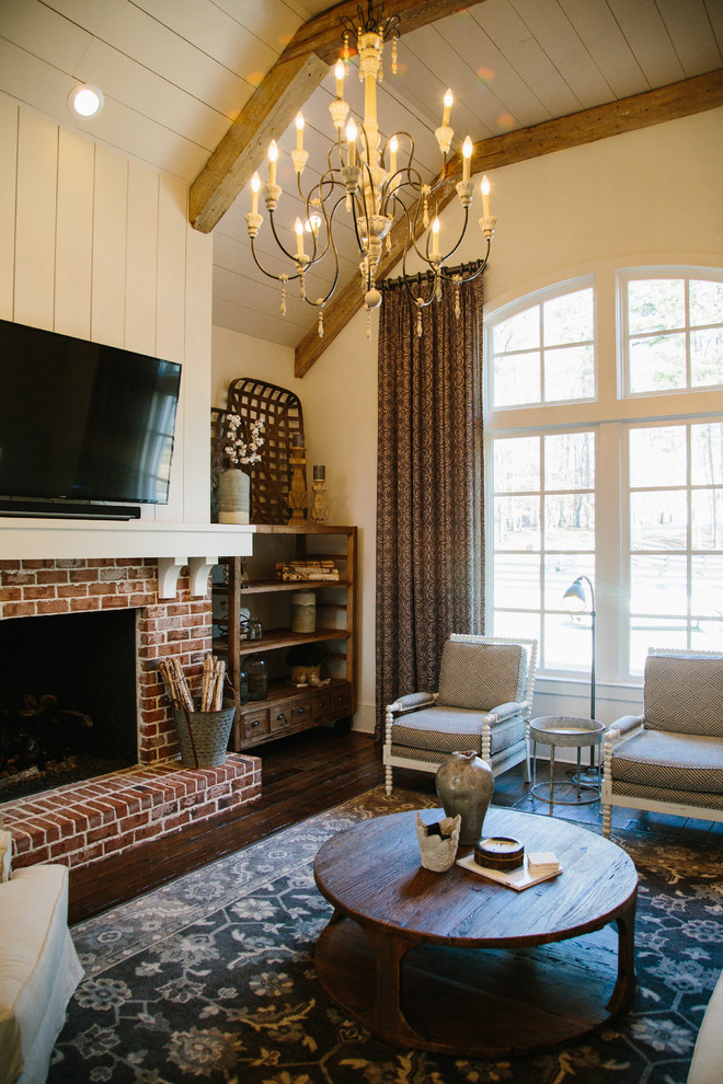 Inspiration for a mid-sized farmhouse formal and enclosed medium tone wood floor living room remodel in Atlanta with white walls, a standard fireplace, a brick fireplace and a wall-mounted tv