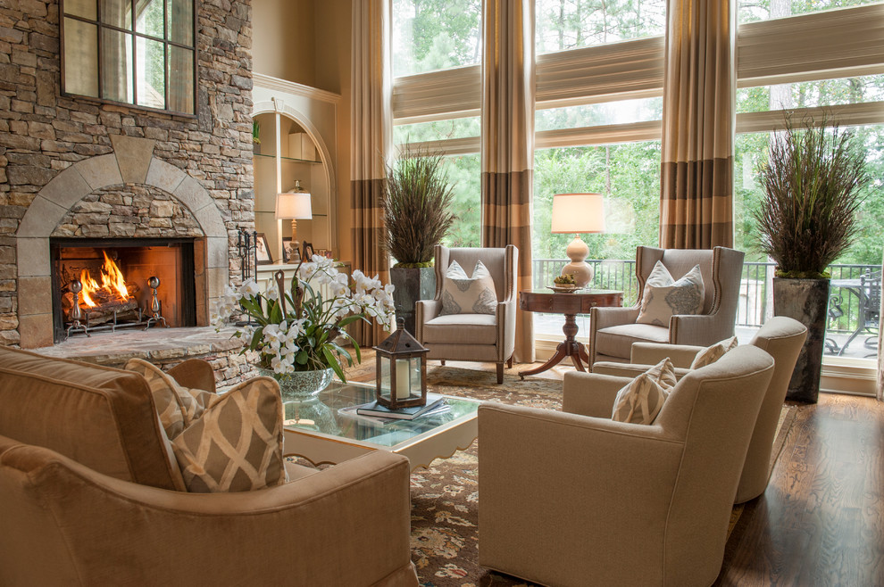 This is an example of a medium sized traditional formal open plan living room in Atlanta with a standard fireplace, a stone fireplace surround, beige walls, medium hardwood flooring, no tv, brown floors and feature lighting.