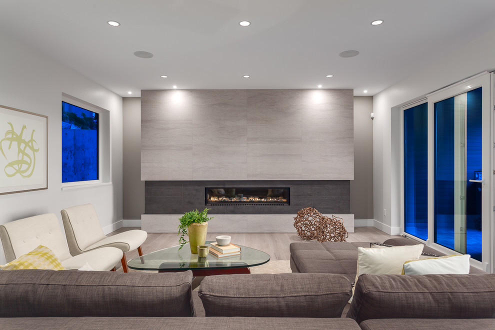 Стильный дизайн: большая открытая гостиная комната в современном стиле с серыми стенами, горизонтальным камином, фасадом камина из плитки, светлым паркетным полом и коричневым диваном без телевизора - последний тренд