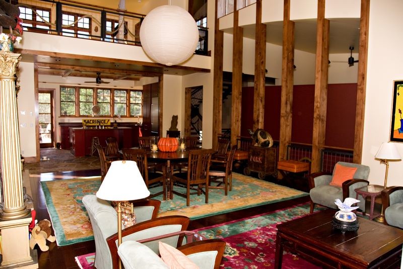 Exemple d'un grand salon mansardé ou avec mezzanine montagne avec un mur blanc, parquet foncé, une cheminée standard et un manteau de cheminée en béton.