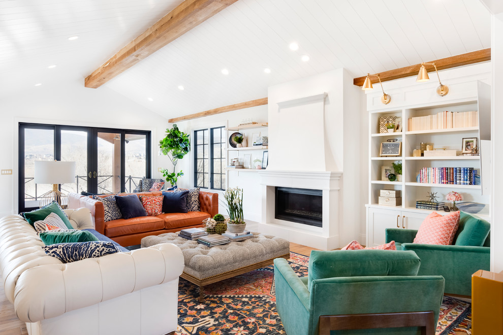 Idee per un grande soggiorno chic aperto con pareti bianche, pavimento in legno massello medio, camino classico e pavimento marrone