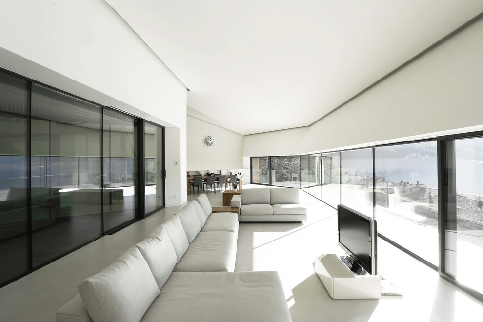 Offenes, Geräumiges Modernes Wohnzimmer mit weißer Wandfarbe, freistehendem TV und Porzellan-Bodenfliesen in Mailand