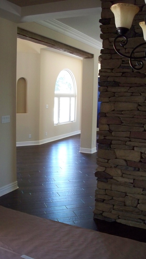 Eklektisches Wohnzimmer mit dunklem Holzboden, beiger Wandfarbe, Tunnelkamin und Kaminumrandung aus Stein in San Diego