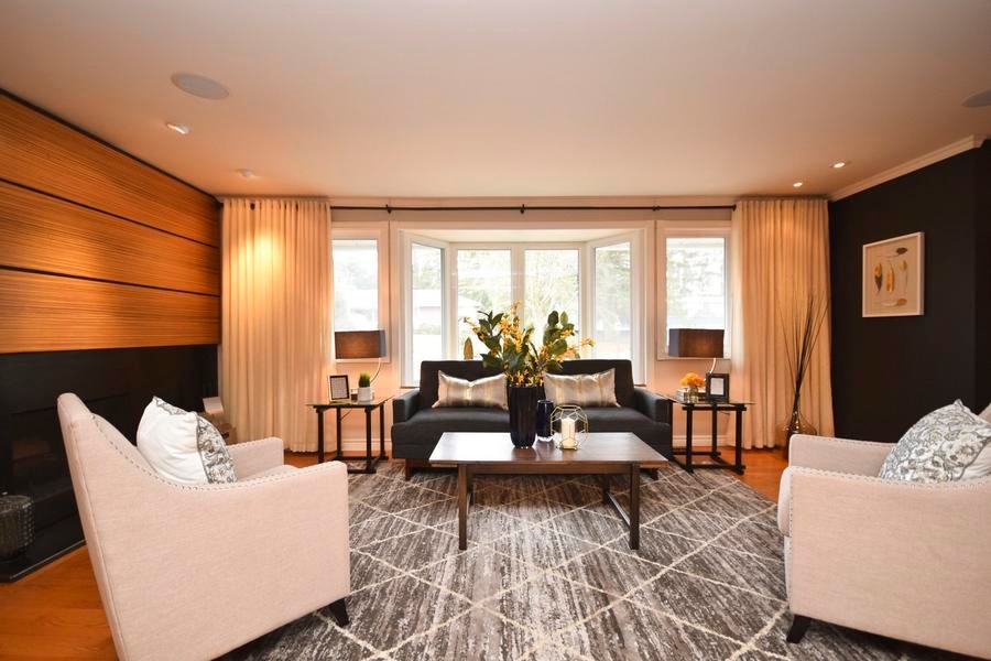 Photo of a large eclectic open plan living room in Ottawa with black walls, medium hardwood flooring, a standard fireplace and a wooden fireplace surround.