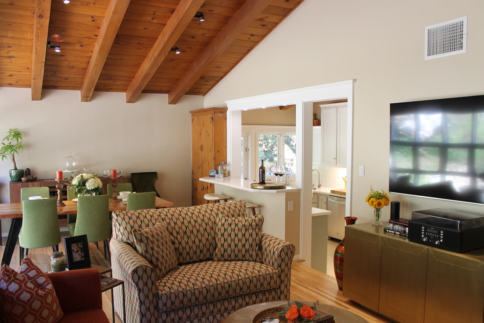 Foto di un grande soggiorno moderno aperto con pareti beige, parquet chiaro, camino classico, cornice del camino in mattoni, TV a parete e pavimento marrone