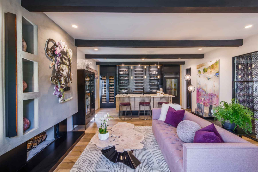 Foto di un soggiorno moderno di medie dimensioni e aperto con pareti grigie, parquet chiaro, camino classico, cornice del camino in metallo e pavimento marrone