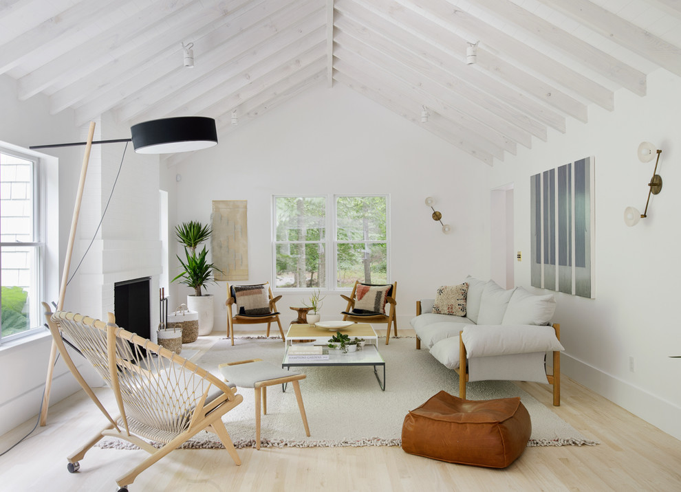 Living room - scandinavian enclosed light wood floor living room idea in New York with white walls and a standard fireplace