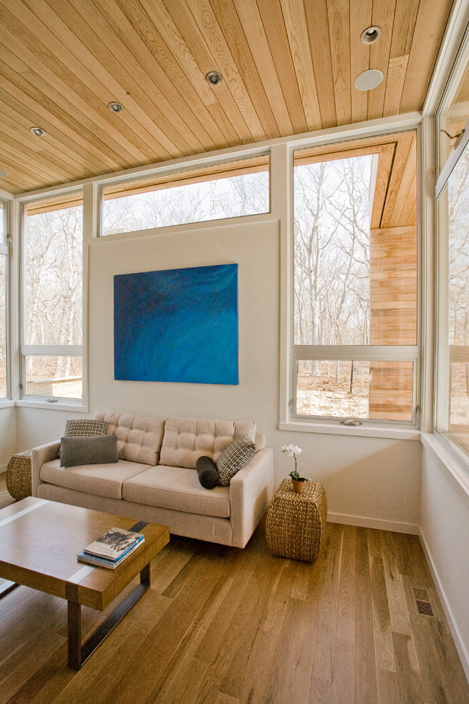 Imagen de salón para visitas abierto moderno grande sin chimenea y televisor con paredes blancas, suelo de madera clara y suelo beige