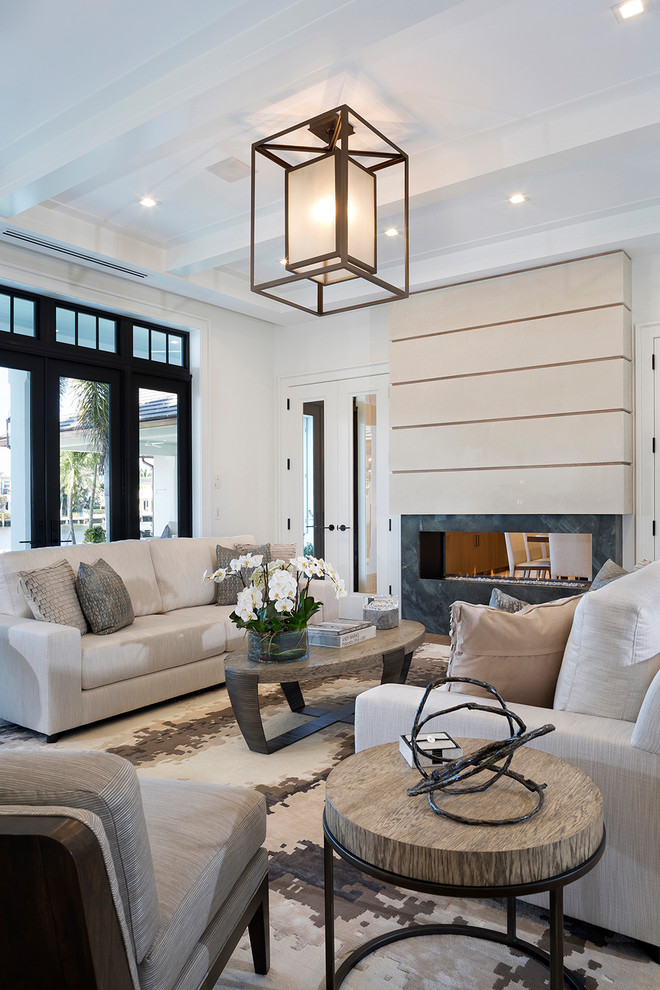 Inspiration for a large contemporary formal and enclosed living room remodel in Miami with white walls, a two-sided fireplace, a stone fireplace and no tv