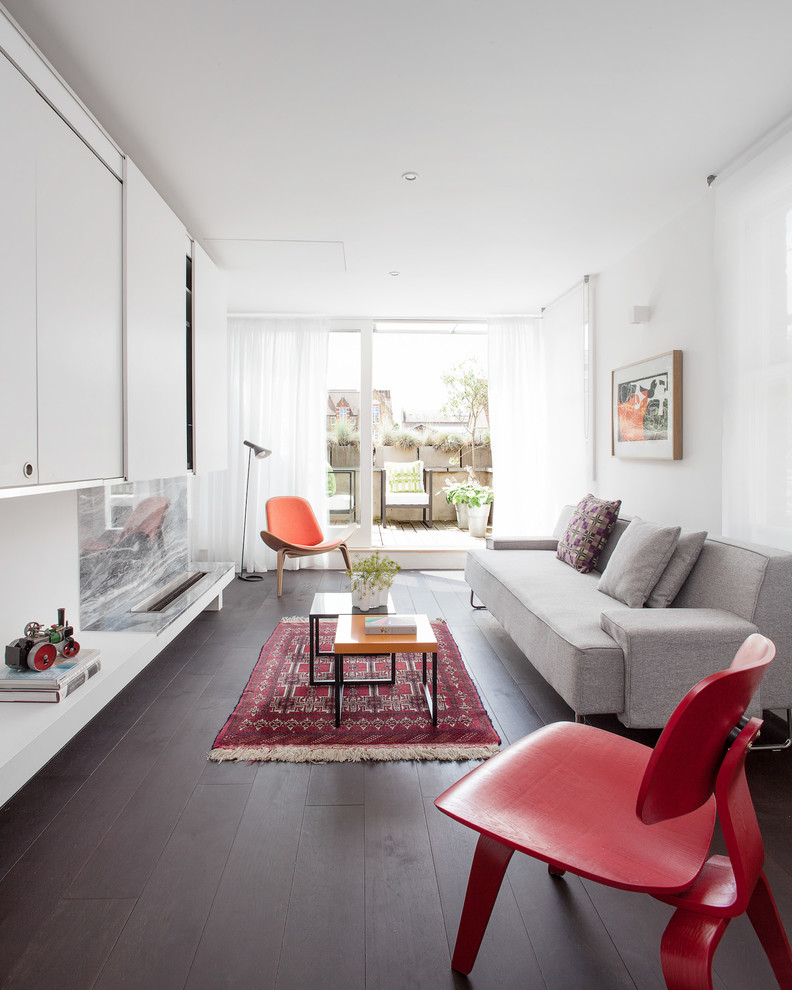 Mittelgroßes, Repräsentatives Modernes Wohnzimmer mit Kaminumrandung aus Stein, weißer Wandfarbe, dunklem Holzboden und Gaskamin in London