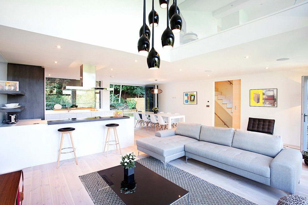 Mittelgroßes, Offenes Modernes Wohnzimmer mit weißer Wandfarbe, hellem Holzboden und beigem Boden in Surrey