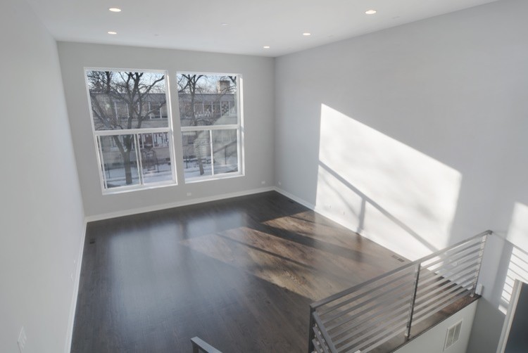 This is an example of a small traditional mezzanine living room in Chicago with grey walls, dark hardwood flooring, no fireplace and brown floors.