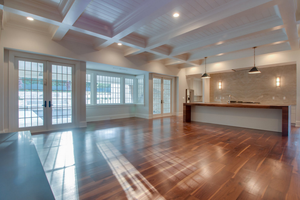 Cette photo montre un grand salon chic ouvert avec un mur blanc et un sol en bois brun.