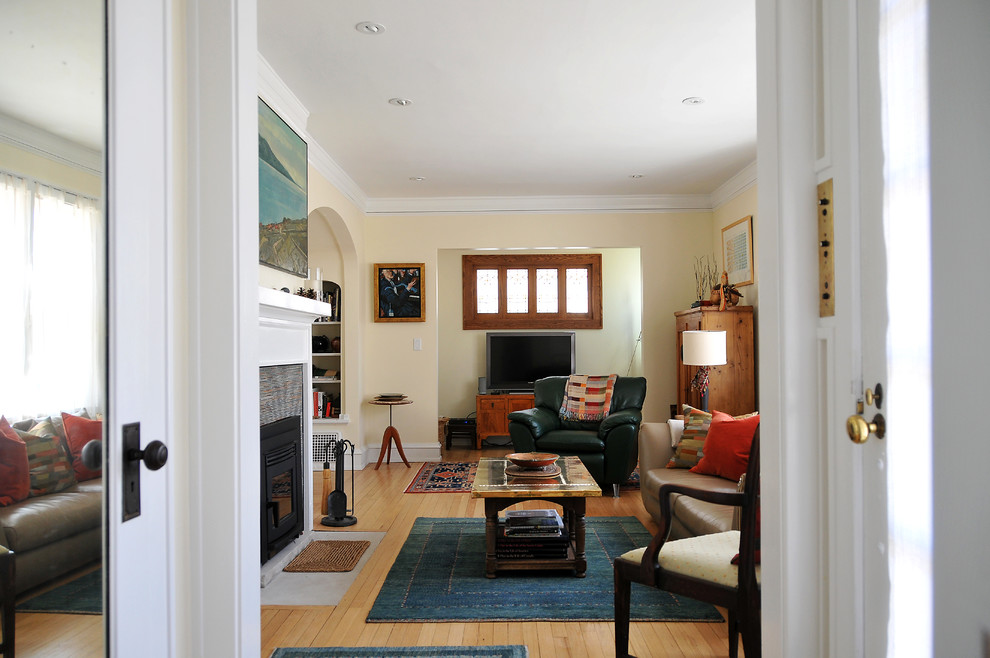 Kleines, Abgetrenntes Klassisches Wohnzimmer mit hellem Holzboden, Kaminofen und gefliester Kaminumrandung in Milwaukee