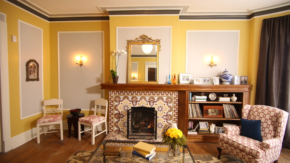 Inspiration för klassiska vardagsrum, med gula väggar, en standard öppen spis och en spiselkrans i trä