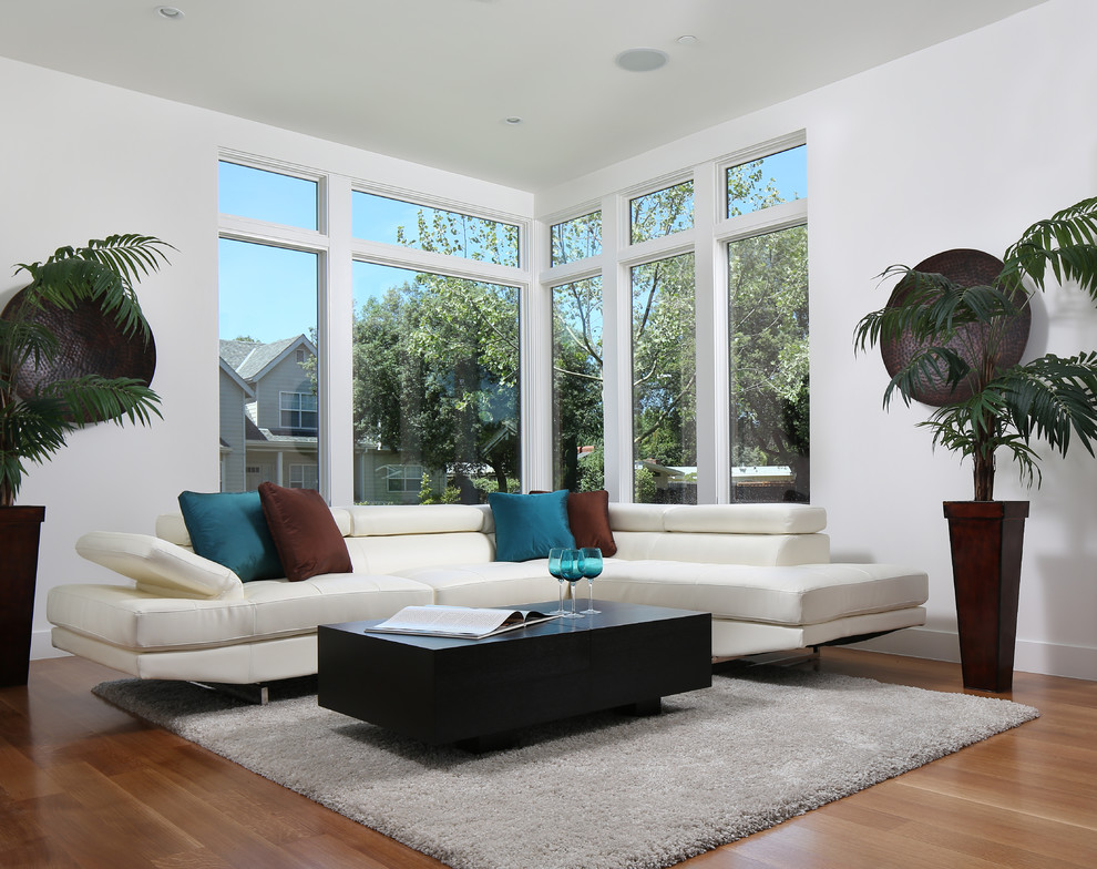 Immagine di un soggiorno contemporaneo aperto con pareti bianche e pavimento in legno massello medio