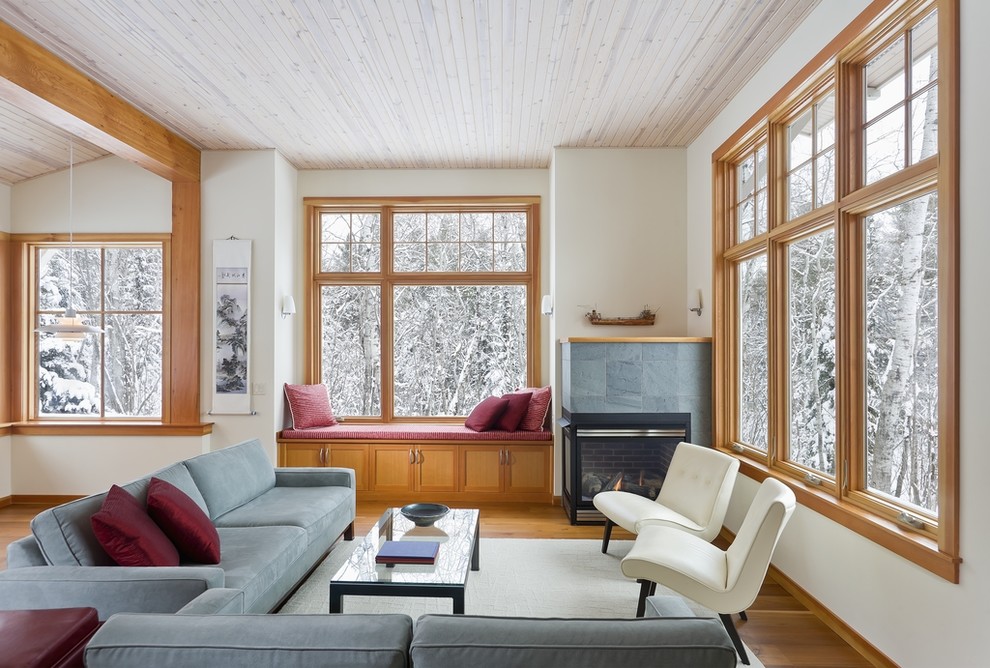 Aménagement d'un salon montagne ouvert avec un mur blanc, un sol en bois brun et une cheminée standard.