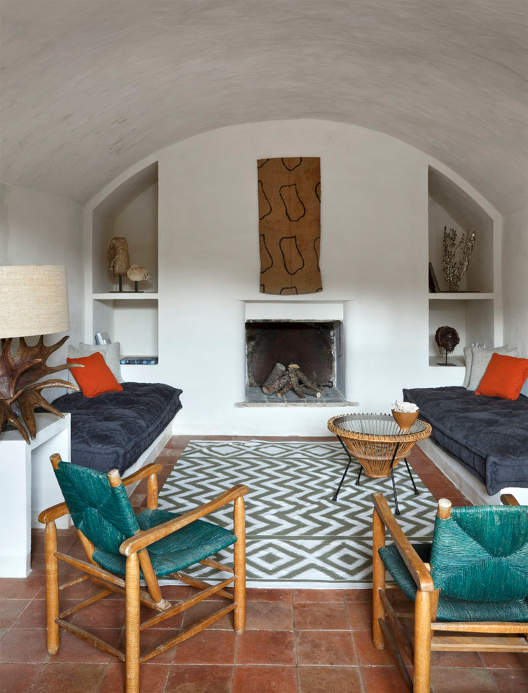 Eklektisk inredning av ett vardagsrum, med ett finrum, vita väggar, klinkergolv i terrakotta, en standard öppen spis och en spiselkrans i gips