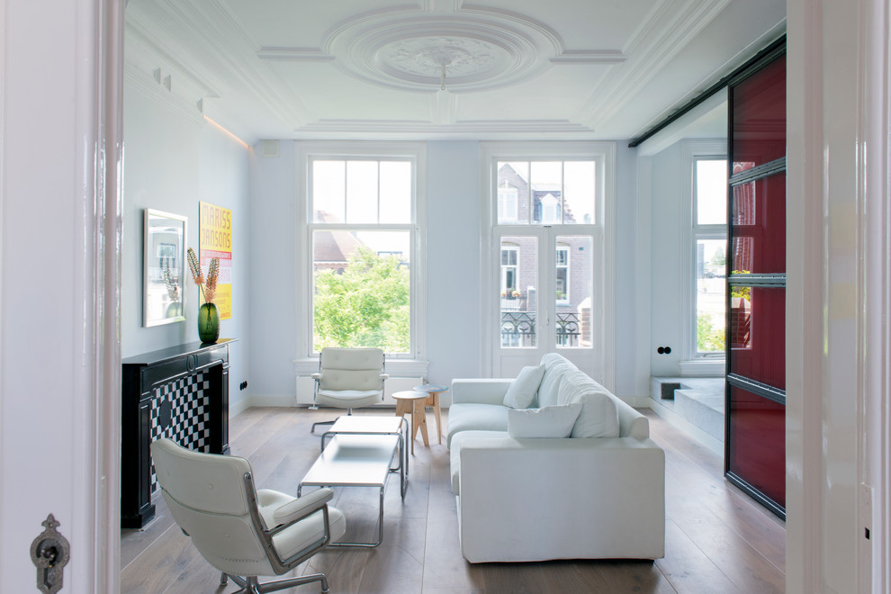 Foto di un soggiorno minimalista di medie dimensioni e aperto con pareti bianche, parquet chiaro, camino classico, cornice del camino in pietra e TV autoportante