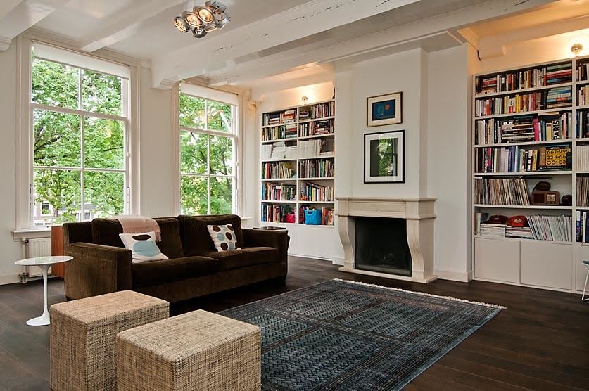 Photo of a medium sized scandi open plan living room in Amsterdam with a reading nook, white walls, dark hardwood flooring, a standard fireplace, a stone fireplace surround, no tv and brown floors.